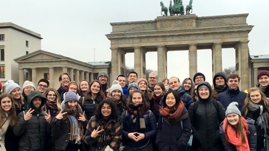 A group of students posing in front of the Brandenburg Gate in Berlin, Germany.